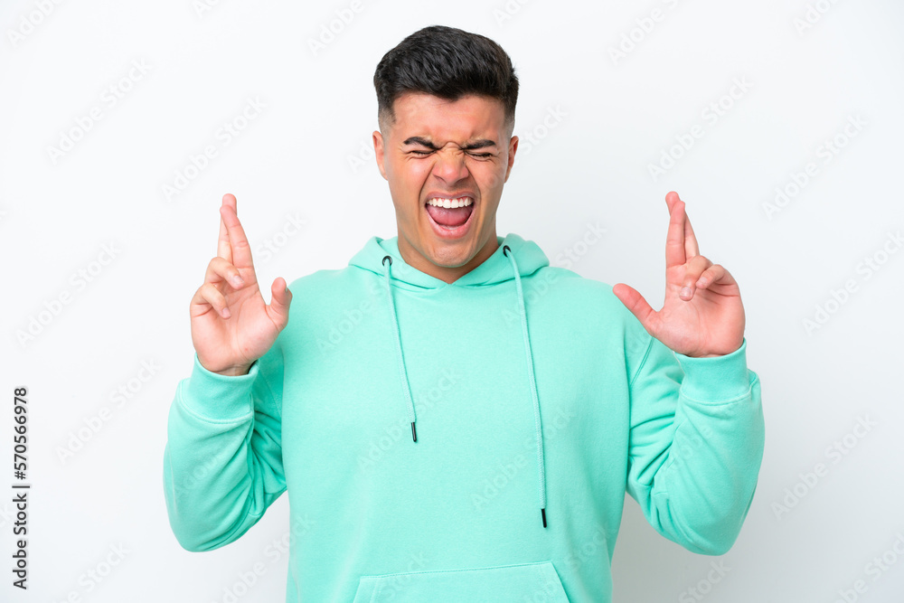 Young caucasian handsome man isolated on white background with fingers crossing Young caucasian handsome man isolated on white background with fingers crossing