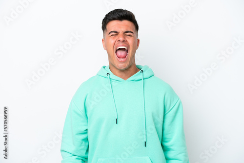 Young caucasian handsome man isolated on white background shouting to the front with mouth wide open © luismolinero