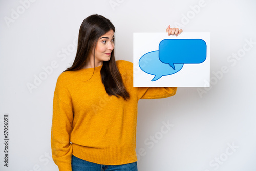 Young Brazilian woman isolated on white background holding a placard with speech bubble icon