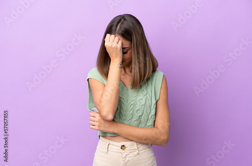 Young caucasian woman isolated on purple background with headache