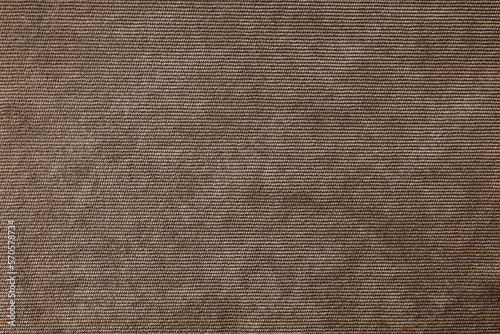 Texture background of velours brown fabric. Upholstery velveteen texture fabric, corduroy furniture textile material, design interior, decor. Ridge fabric texture close up, backdrop, wallpaper.