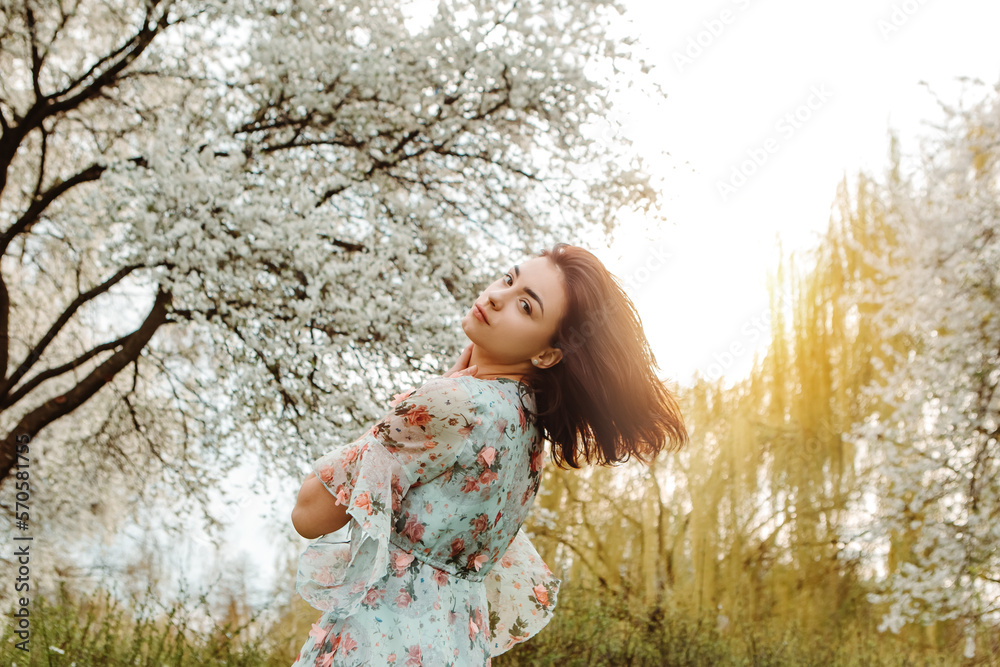Woman looking over the shoulder dressed flowery dress posing near apple cherry tree blossoms blooming flowers in the garden park in early spring nature. Fashion, girl model with black hair
Woman looking over the shoulder dressed flowery dress posing near apple cherry tree blossoms blooming flowers in the garden park in early spring nature. Fashion, girl model with black hair