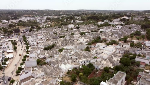 Aerial drone footage of Alberobello, Puglia, Italy. Establish scene of the traditional whitewashed, conical roof (trulli) UNESCO world heritage site, landmark tourist destination from above.