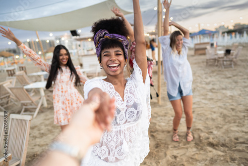 Принти на полотні Multiethnic group of young women dancing at chiringuito beach during sunset