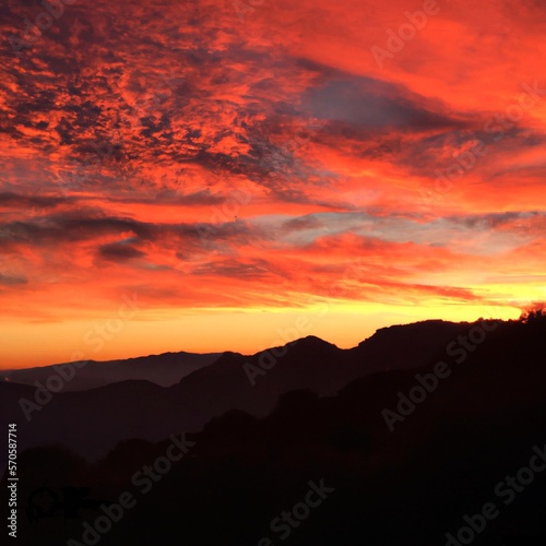 A red-orange sunset over a mountainous landscape