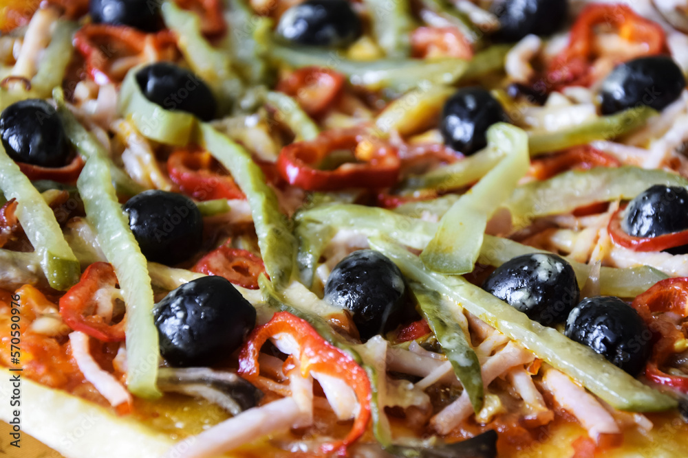 Part of freshly prepared Italian homemade pizza: olives, ham, pepper, sauce, cucumber, cheese. Close-up. Selective focus. Part of freshly prepared Italian homemade pizza: olives, ham, pepper, sauce, cucumber, cheese. Close-up. Selective focus.