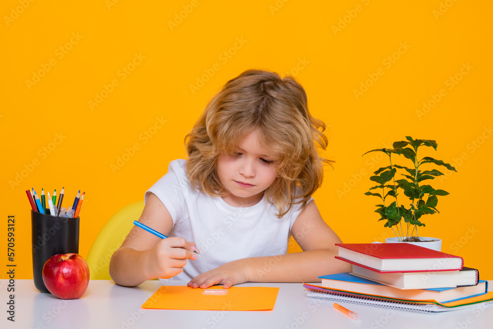 Child writing lesson. School and education concept. Portrait of cute child school boy, isolated on yellow background. Back to school. Child writing lesson. School and education concept. Portrait of cute child school boy, isolated on yellow background. Back to school.