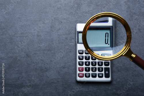 Financal concepts, a calculator showing zero with magnifying glass photo