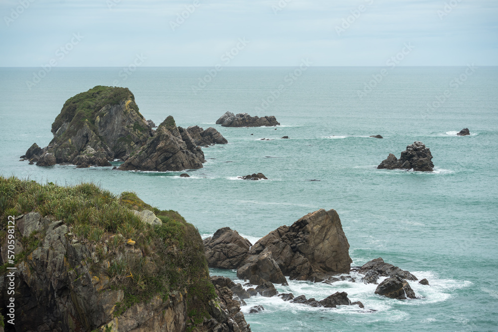 Raue Westküste Neuseelands mit Meer, Urwald, Wellen und Felsen.