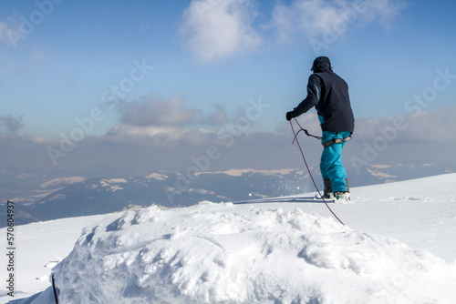 Climber prepares to descend from snow-covered mountain