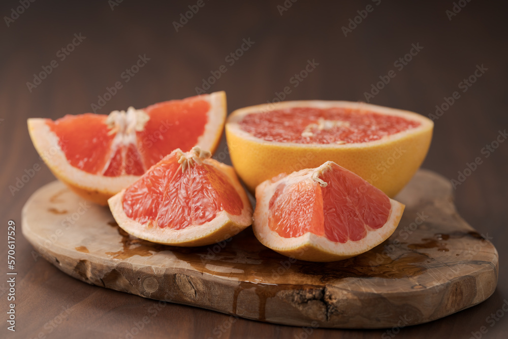 Sliced grapefruit on wood board closeup Sliced grapefruit on wood board closeup