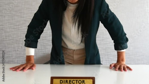 Young caucasian brunette business woman director in office swear shout standing at you pov with hands knock punch table in office