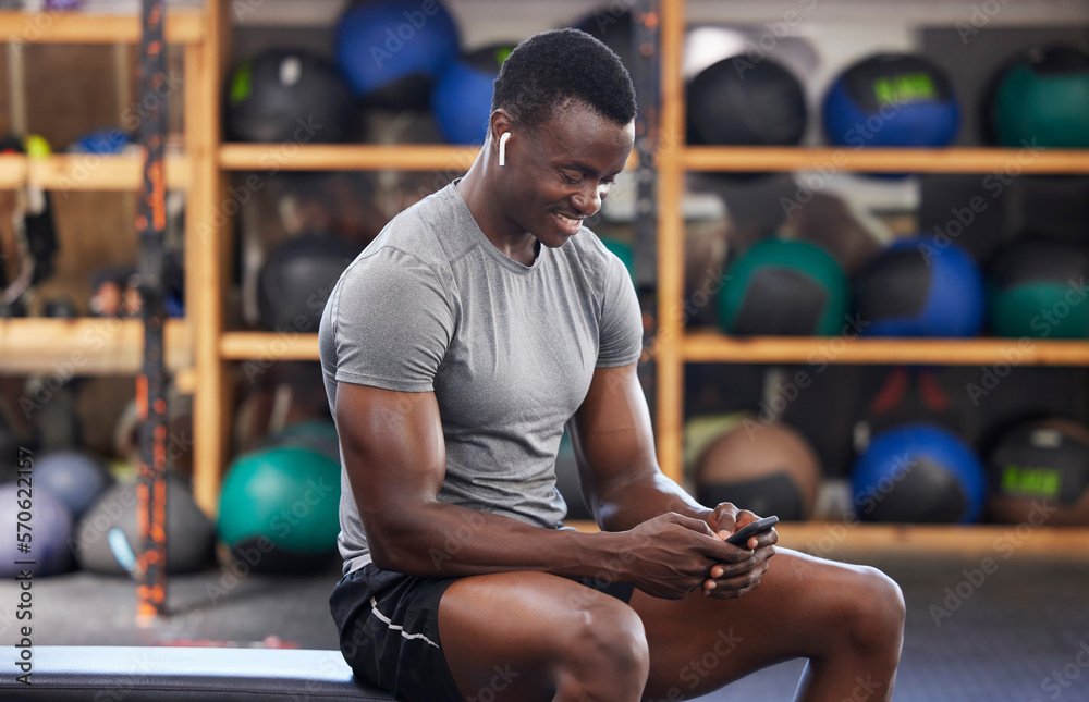 Phone, fitness and black man in gym training, workout or exercise social media or internet search for health tips. Bodybuilder, sports person listening to music or typing on smartphone chat or mobile