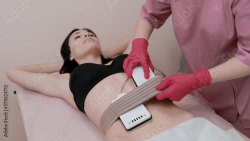 The masseur does myostimulation of the body. Body care. The girl does the procedure.Fast burning of excess pounds of fat without effort
