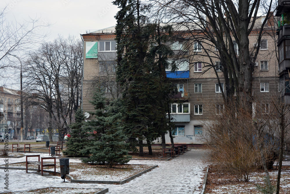 Winter photos of the big street Rabochaya in the city of Dnipro, ukraine. Wide road, parks, yards with cars, people, trees, Christmas trees, big houses and shops on a weekday.