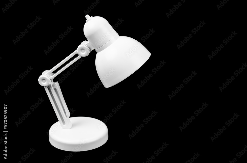 The White folding table lamp on black background. The White folding table lamp on black background.