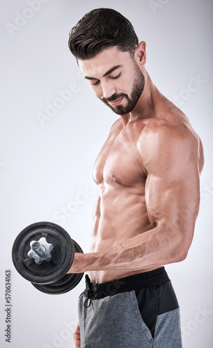 Fitness  power or strong man with a dumbbell in training  exercise or gym workout for body goals. Sports motivation  focus or healthy bodybuilder weightlifting for biceps growth isolated in studio