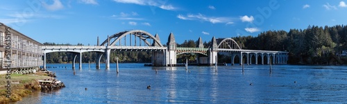 Panoramic view of the Siuslaw River Bridge and the buildings on the left bank, on a sunny afternoon