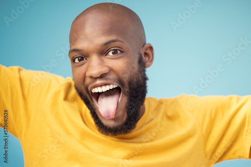 Black man, portrait or tongue on blue background, isolated mockup or wall backdrop mock up for comic, silly or emoji expression. Happy, funny face or goofy student with fashion, trend or cool clothes