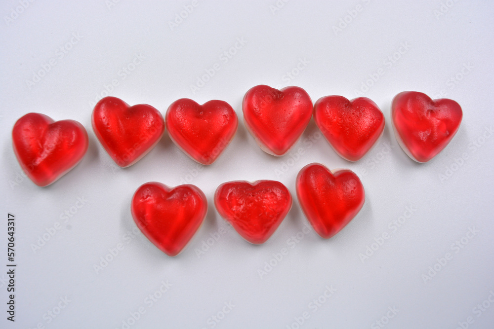 Bright and colorful children's sweets, delicious pink jelly candies on a white pillow in the form of a heart. A lot of hearts are placed on a white background, Valentine's Day, a lot of love.