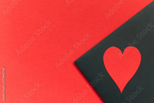 Czarna koperta na tekst walentynkowy lub miłosny ozdobiona czerwonymi sercami na czerwonym romantycznym tle.