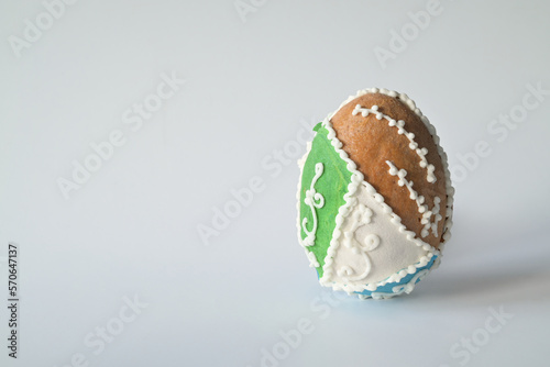 kolorowe jajko pisanka wielkanocna wykonana z ciasta ozdobiona kolorowym lukrem na jasnym tle