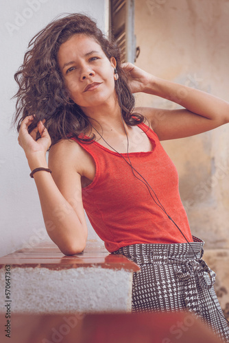 Mulher morena com cabelos cacheados em transição capilar. Mulher desfrutando de cabelo volumoso. Brunette woman with curly hair in hair transitioning. Woman enjoying voluminous hair.