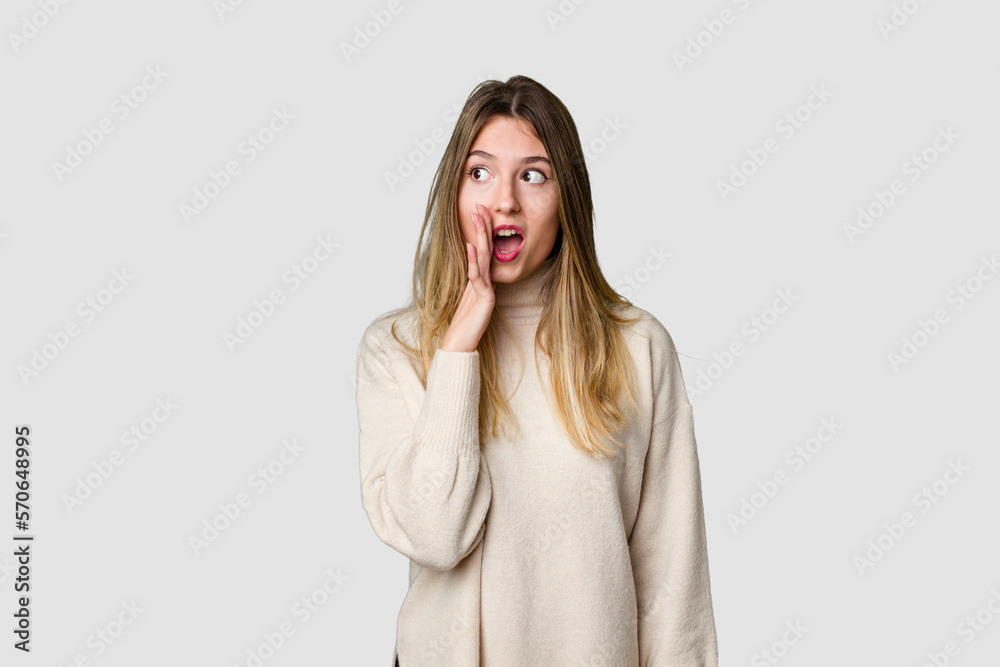 Young blonde posing for a portrait isolated, exuding natural beauty and radiance is saying a secret hot braking news and looking aside Young blonde posing for a portrait isolated, exuding natural beauty and radiance is saying a secret hot braking news and looking aside