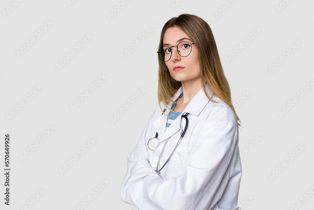 Young female doctor confidently gazing at the camera. Young female doctor confidently gazing at the camera.