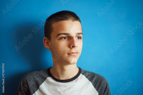 Photo of adorable young happy boy looking at camera.Isolated on the light blue background