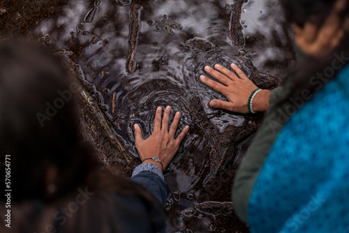 Two hands of women in love touching the water surface together. Concept environment, earth day