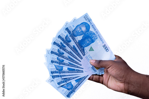 A black hand holding a spread of the New Nigerian currency / money, the 1000 Naira note on a white background photo