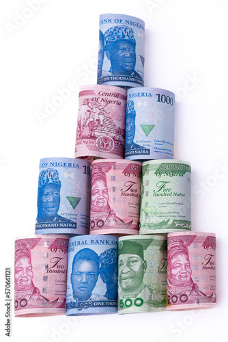 The new Nigerian currency / money, the 200, 500 and 1000 Naira notes, rolled and lying in a pyramid shape on a white background