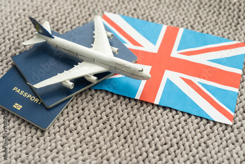 Tourim flight to the Grean Britain concept. Vacation in the United Kingdom. Composition of the UK flag, passport and toy airplane. photo