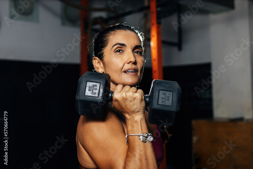 Obraz na plátne Fitness determined mature woman working out at the gym