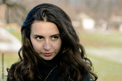Mysterious girl.Portrait of a woman in nature.Winter portrait.Beautiful long hair.Confident woman.Girl plays with her hair.Lonely girl.Woman dreams and thinks.The girl is sad.Confident woman. Cunning.