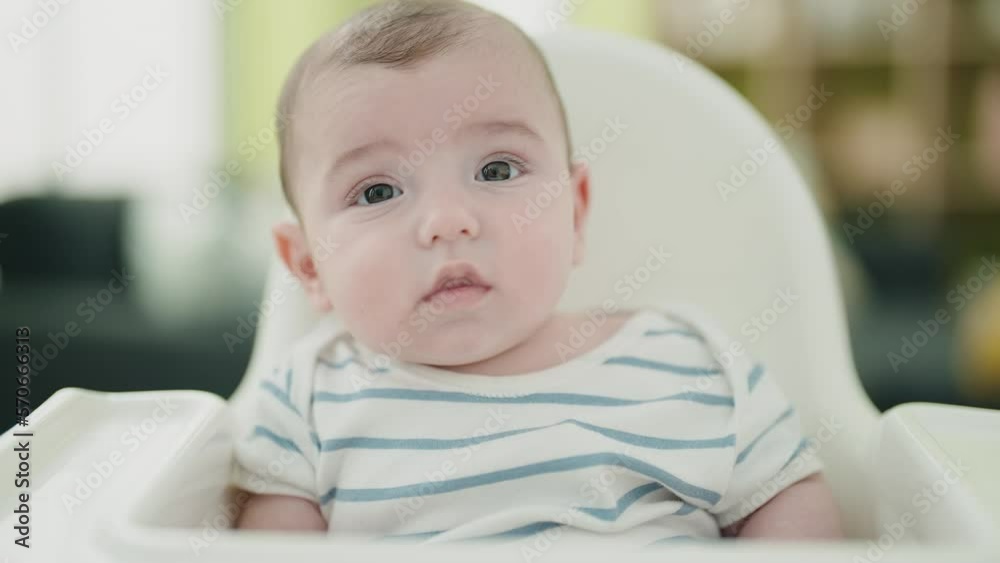 Adorable caucasian baby sitting on highchair at home Adorable caucasian baby sitting on highchair at home