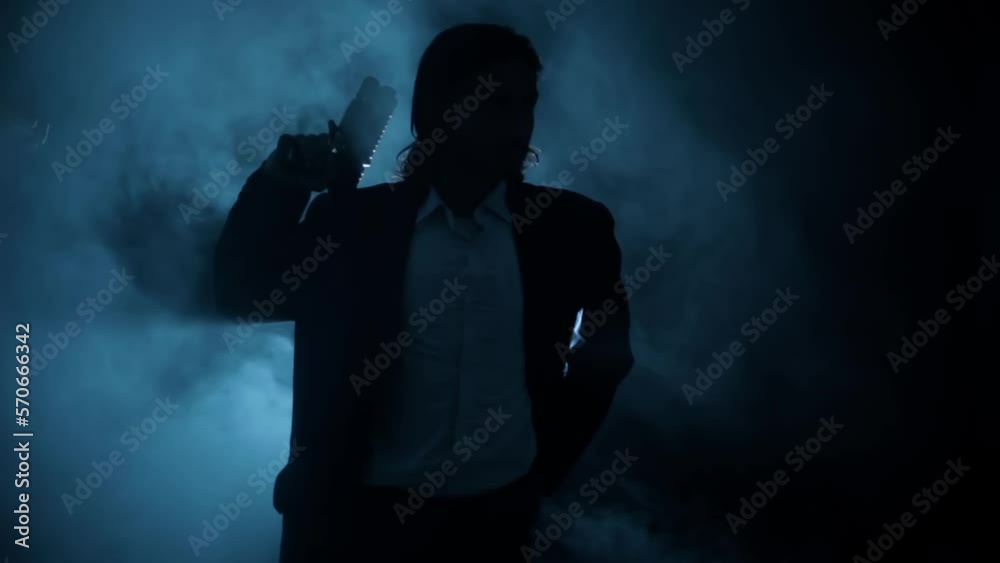Shot of a young hitman in a blue colored coat with his gun resting on his shoulder HD footage. Shot of a young hitman in a blue colored coat with his gun resting on his shoulder HD footage.
