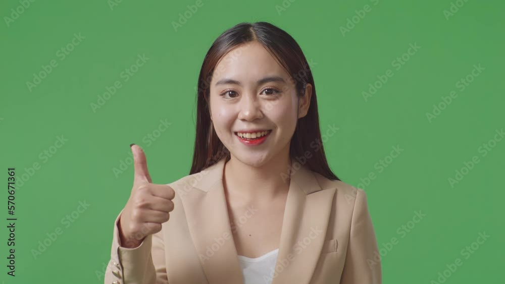 Close Up Of Asian Business Woman Showing Thumbs Up Gesture And Smiling While Standing In The Green Screen Studio
Close Up Of Asian Business Woman Showing Thumbs Up Gesture And Smiling While Standing In The Green Screen Studio