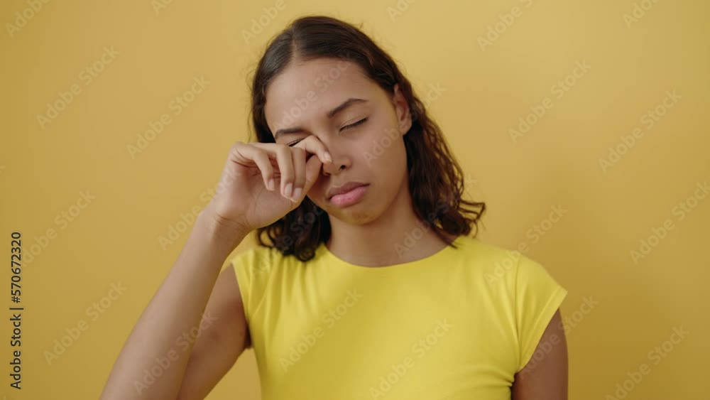 Young african american woman yawning over isolated yellow background Young african american woman yawning over isolated yellow background
