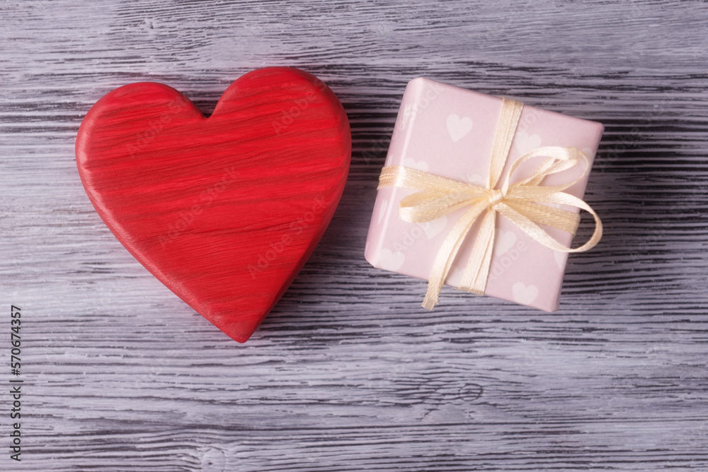 Fototapeta premium Red valentines heart and gift box on wooden background. Valentine’s day gift concept