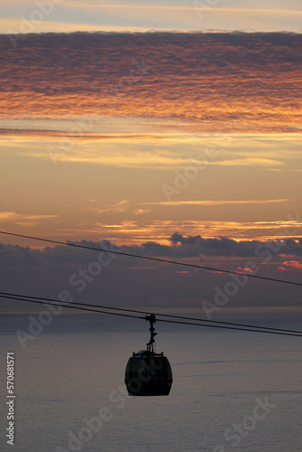 Cable car cabin over the Mediterranean sea at sunset with clouds