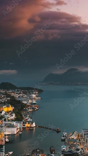 Alesund, Norway. Day To Night Time-lapse. Dramatic Sky In Warm Colours Above Alesunds Islands In Sunset Time. Famous Town In Evening Night Time. Vertical, Vertical Shot, Vertical Video, photo
