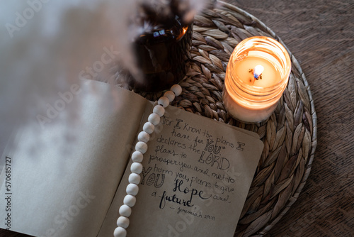 Close-up of bible verse mock-up with pampass grass, amber glass, rattan, and candle