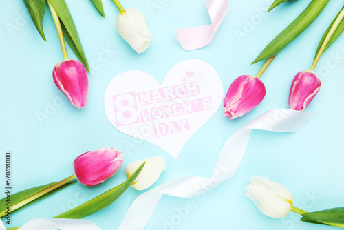 Flowers of tulips and card in shape of heart with text 8 march Women's Day, ribbons, on blue background