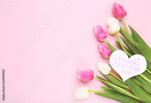 Tulips and card in shape of heart with text 8 march Women's Day on pink background