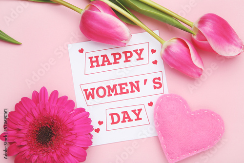 Gerbera and tulips flower , felt heart and card with text Happy Women's Day on pink background
