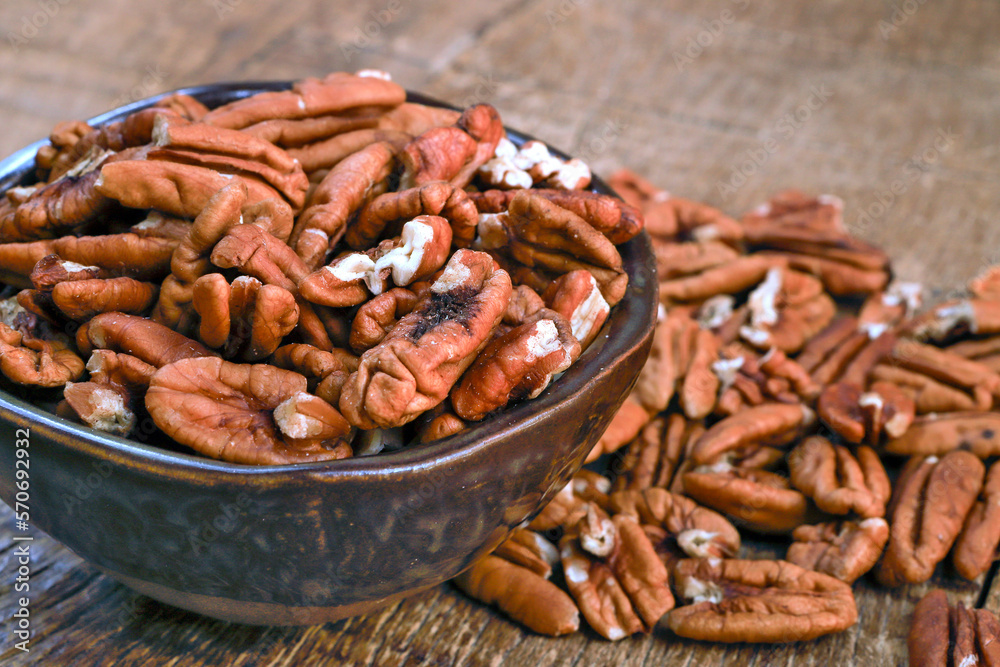 Obraz premium Bowl with pecan on rustic wooden table