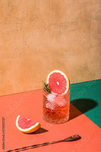Red cocktail in base of Campari or bitter with blood red oranges (tarocco) on the geometric  background. Aperitif with Americano or Negroni cocktail. Retro chic style, vintage props

