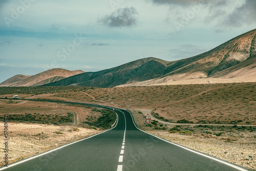 Foto Charming cinematic road in Spain with vehicle in the distance with desert on bot